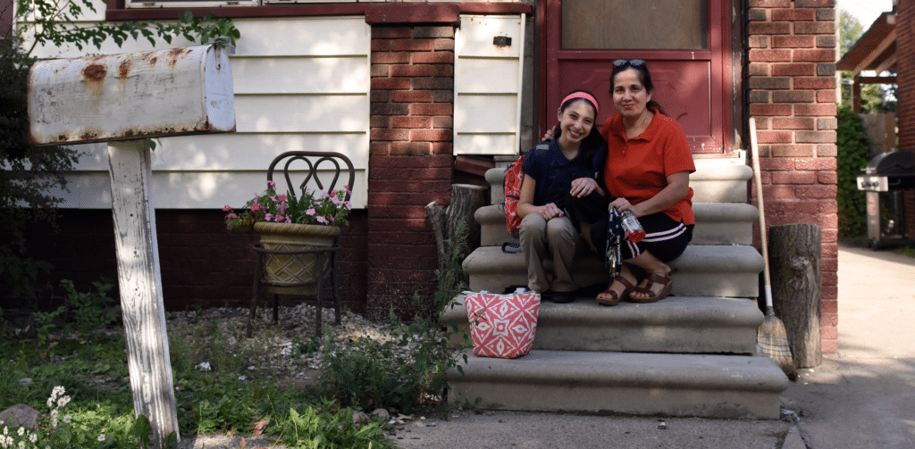 Mayra and daughter on steps of their home