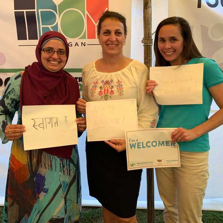 women holding up welcoming signs