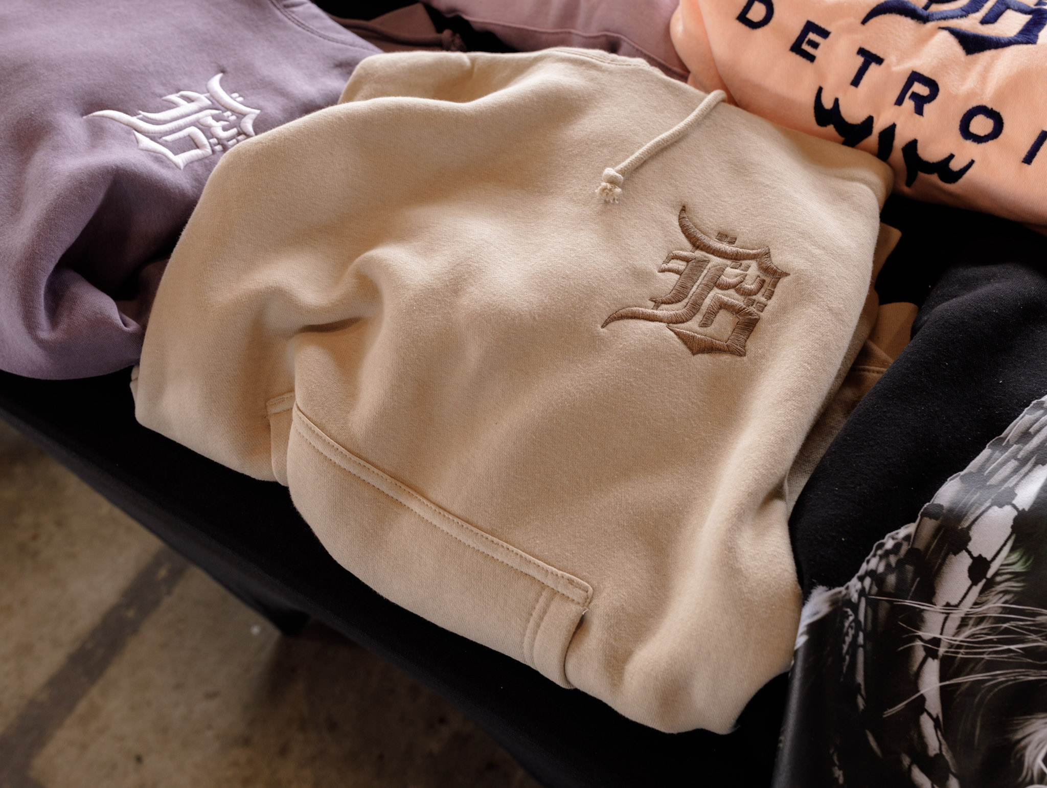 Tan sweatshirt with an English 'D' on it, sitting on table