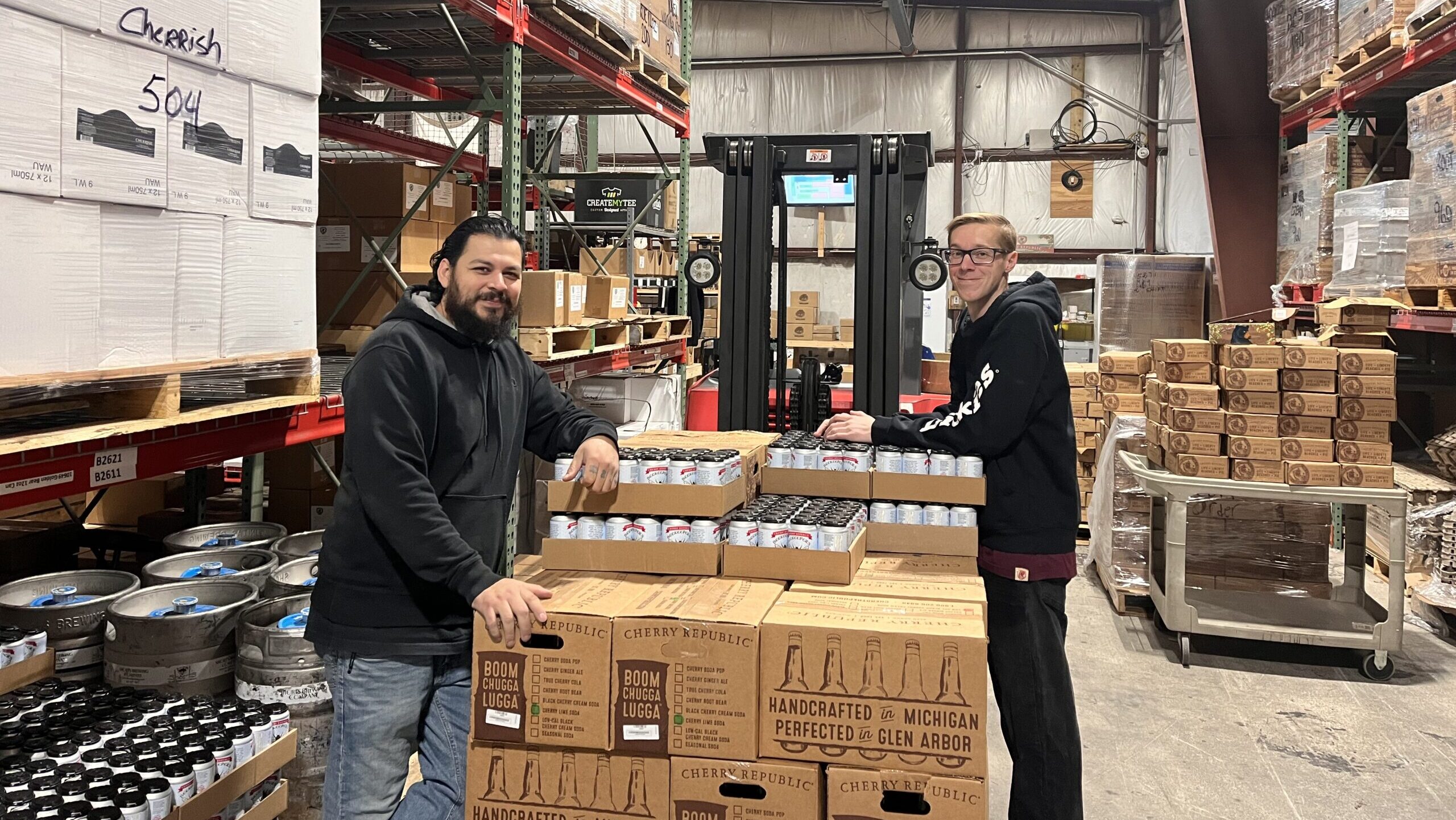 Two men standing beside boxes in a warehouse